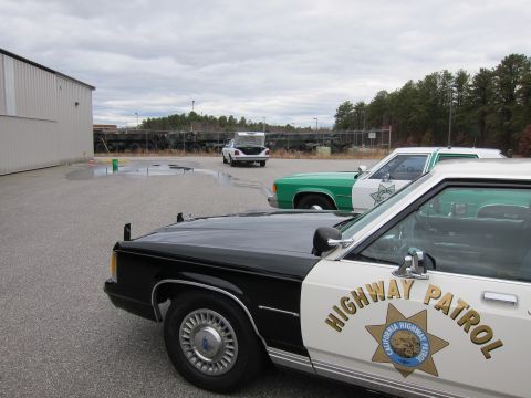 1991 Ford LTD Crown Victoria - Two California Highway Patrol cars are parked in an outdoor lot, with a white sedan in the background.