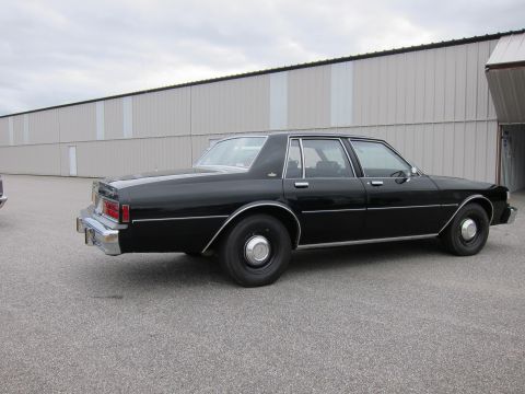 1991 Ford LTD Crown Victoria - Side view of a black sedan parked outdoors.