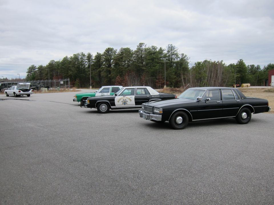 Black police car, side view, with a visible badge on the door