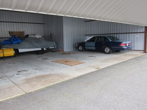 1991 Ford LTD Crown Victoria - A two-tone blue 1991 Ford Crown Victoria LTD is parked inside a storage unit alongside another covered vehicle.