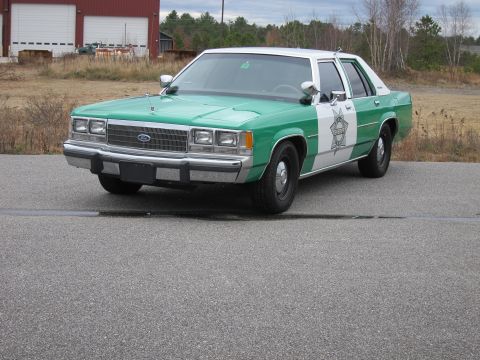 1991 Ford LTD Crown Victoria - This Ford Crown Victoria police car has a distinctive green and white paint scheme with a sheriff's star emblem on the door.