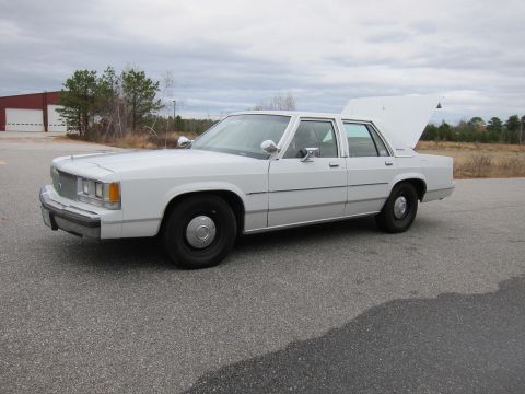 1991 Ford LTD Crown Victoria - White 1991 Ford Crown Victoria LTD sedan with its trunk open, parked outdoors.
