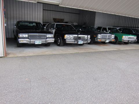 1991 Ford LTD Crown Victoria - Several sedans are parked in a garage, with the 1991 Ford Crown Victoria LTD visible.
