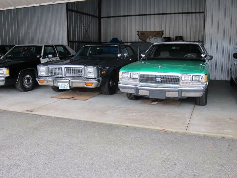 1991 Ford LTD Crown Victoria - A green Ford Crown Victoria is parked in a garage alongside other vehicles.