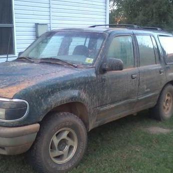 1993 Ford F-150 - This green Ford Explorer is covered in mud, suggesting recent off-road use.