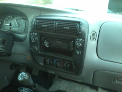 1993 Ford F-150 - The interior of a truck is shown, the dashboard, air vents, radio, and gear shifter.