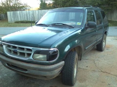 1993 Ford F-150 - A green Ford Explorer SUV is parked on a concrete driveway with a wooden fence in the background.