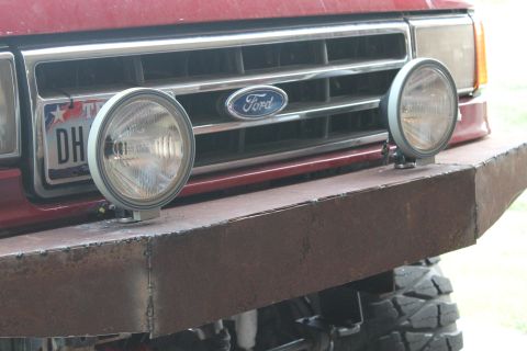 1990 Ford Bronco - Close-up of a Ford truck's front end, a custom bumper and auxiliary lights.