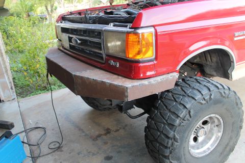 1990 Ford Bronco - Custom bumper installed on a red truck, large off-road tires and a visible 4x4 badge.