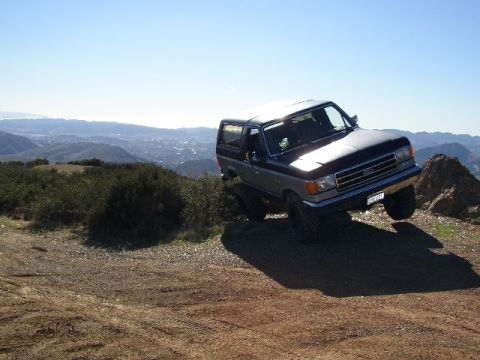 1989 Ford Bronco - Ford Bronco parked on a dirt trail, overlooking a valley on a clear day.