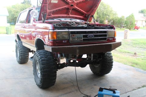 1990 Ford Bronco - This modified Ford Bronco features a custom front bumper and lifted suspension with oversized tires.