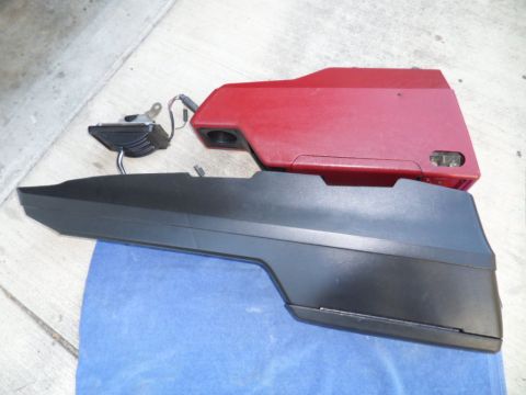 1994 Jeep Cherokee - Two plastic automotive parts, one red and one black, are laid out on a blue cloth on a concrete surface.