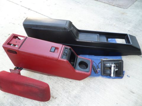 1994 Jeep Cherokee - Two car center consoles and a shifter are laid out on a concrete surface.