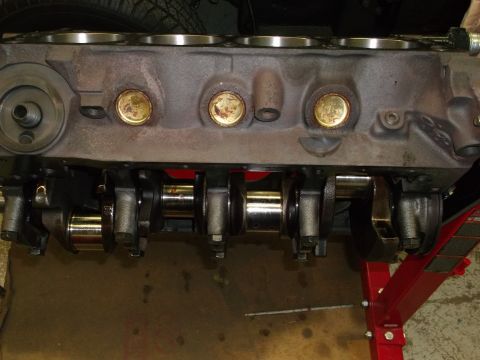1987 Ford Mustang - Close-up view of an engine block and crankshaft assembly, resting on a red engine stand.