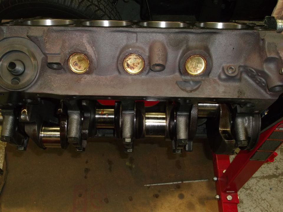 Engine block with crankshaft and connecting rods, supported by a red engine stand