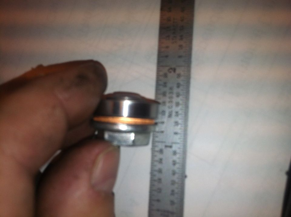 Drain plug with copper washer next to ruler