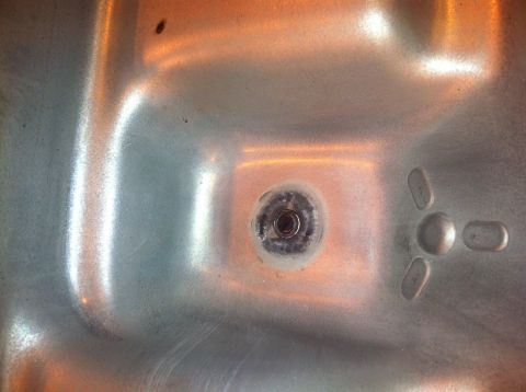 1992 Ford Bronco - This is a close-up view of a transmission pan drain plug, showing some wear and residue around the plug itself.
