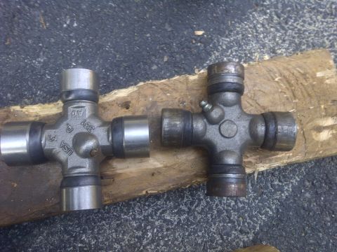 1995 Ford Bronco - Two universal joints are shown side-by-side on a wooden plank.
