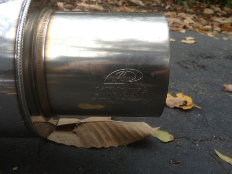 1996 Ford Bronco - This is a close-up of an exhaust muffler with the APEX logo visible. The muffler is resting on the ground with fallen leaves.