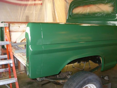 1967 Ford F-250 - A green pickup truck bed is shown in a garage, possibly undergoing restoration or painting.
