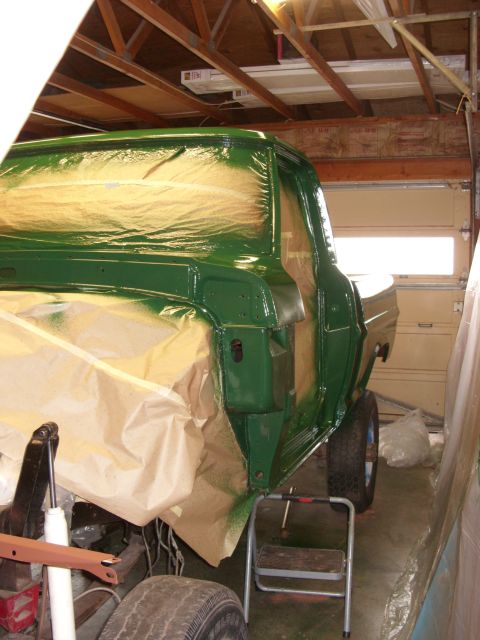 1967 Ford F-250 - A pickup truck is undergoing a paint job in a garage, with protective coverings in place.