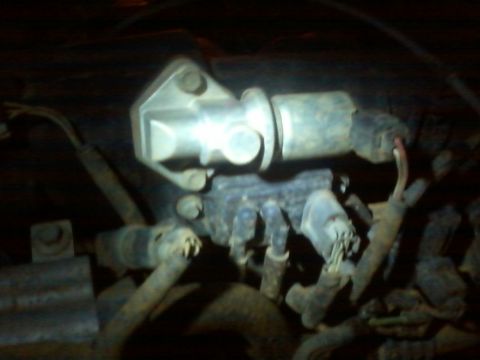 1993 Ford F-150 - This is a close-up view of a vehicle's engine component, likely an actuator or sensor, with associated wiring and tubing.