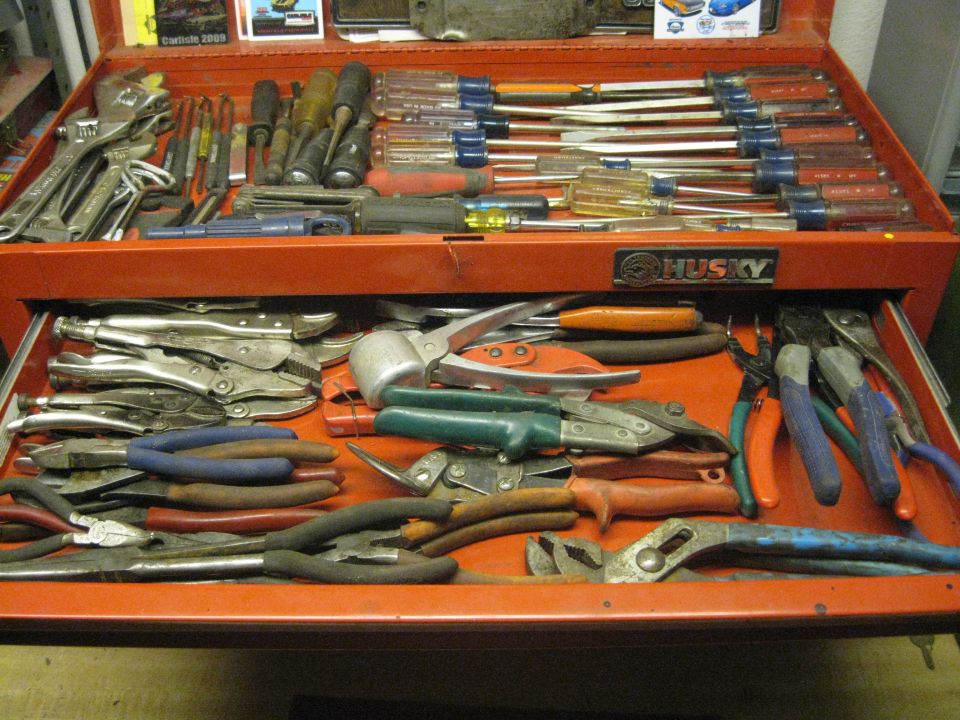 Open red Husky tool chest filled with wrenches, screwdrivers, pliers, and other tools