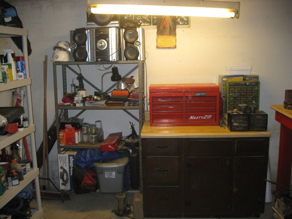 Workshop scene with shelves of tools, a red toolbox, and storage cabinets