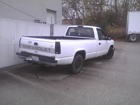 2003 Ford Crown Victoria - A white Chevrolet pickup truck is parked in an outdoor lot.