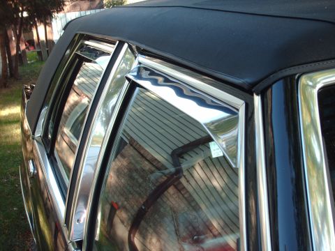 1991 Mercury Grand Marquis - Chrome trim accents the windows and black vinyl top of a car.