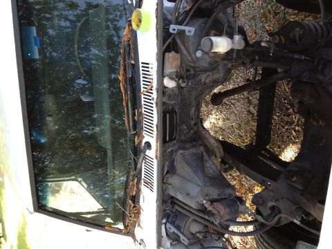1987 Ford Ranger - Engine bay and windshield of a white vehicle, likely from the 1980s, with visible mechanical components.