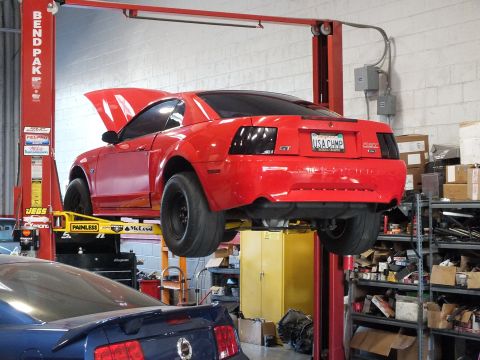 2003 Ford Crown Victoria - Rear underside of a red Mustang GT on a Bend Pak lift with USA CHMP plate and black drag wheels