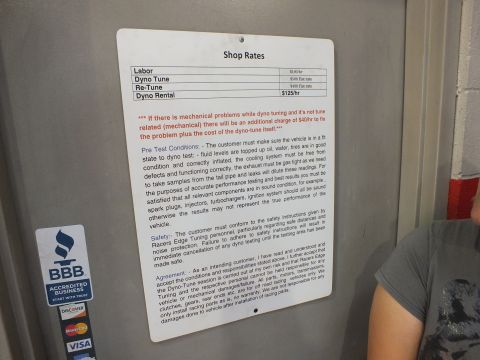 2003 Ford Crown Victoria - posted dyno-shop rates and terms-of-service sign, not a vehicle technical document.