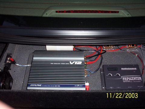 2003 Ford Taurus - The trunk of a car houses a car audio system with two amplifiers and associated wiring, dated 11/22/2003.