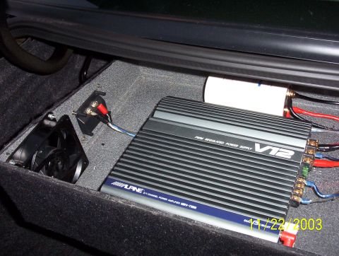 2003 Ford Taurus - An Alpine V12 car amplifier and cooling fan are installed in the trunk of a vehicle, as indicated by the date stamp on the photo.