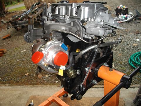 1989 Ford Probe - Engine assembly on a stand, a turbocharger with bright red protective caps.