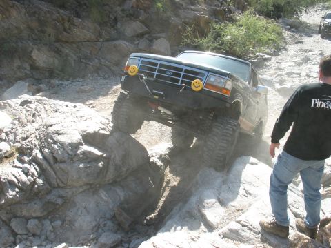 1994 Ford Bronco - This 1994 Ford Bronco is tackling a challenging off-road course with significant rock obstacles.