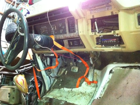 1986 Ford Bronco - The interior of a 1986 Ford Bronco shows exposed wiring and orange straps around the steering column and dashboard.