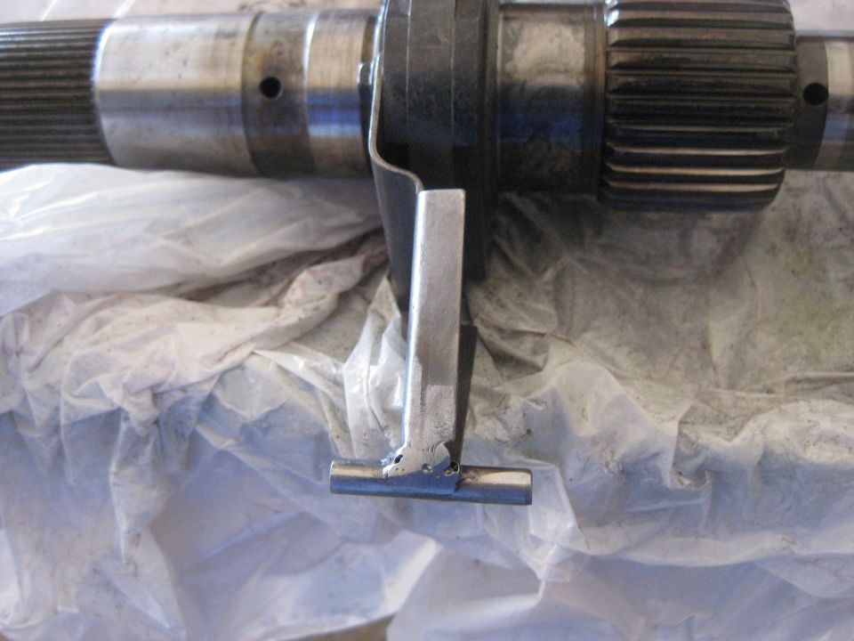Transfer case part with splines and a metal bracket