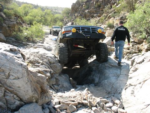 1994 Ford Bronco - This modified SUV navigates a challenging rocky trail, demonstrating its off-road capabilities.