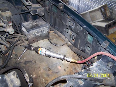 1986 Ford Bronco - Close-up of an engine bay showing an air ratchet tool in use.