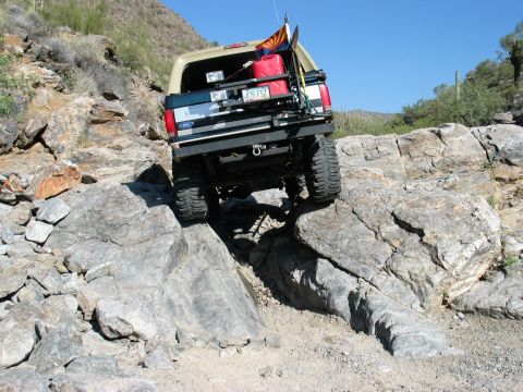 1994 Ford Bronco - This 1994 Ford Bronco is shown off-roading on a challenging rocky terrain, demonstrating its capability on difficult trails.