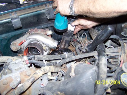 1986 Ford Bronco - Close-up of a vehicle's engine bay, focusing on a turbocharger and various hoses.