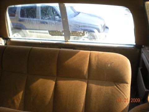 1986 Ford Bronco - View from the back seat of a vehicle, looking out the rear window at a Jeep Liberty parked outside.