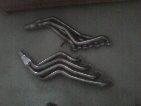 2003 Ford Crown Victoria - Two chrome exhaust headers are shown on a dark surface.