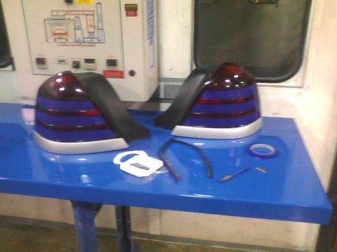 2003 Ford Crown Victoria - Aftermarket tail lights are laid out on a blue table, ready for installation.