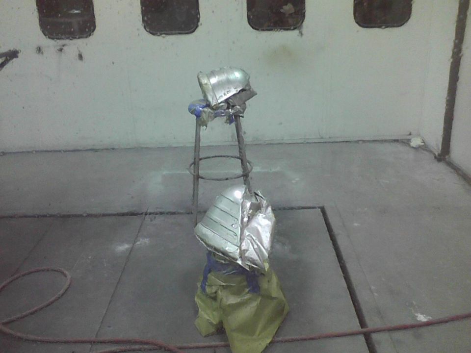 Car fender being prepped for paint in a booth
