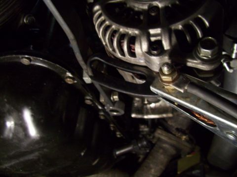 1995 Ford Probe - Close-up view of a car's alternator and surrounding engine components.