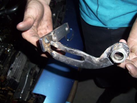1995 Ford Probe - A person holds a custom-fabricated metal bracket, likely for a vehicle repair or modification.
