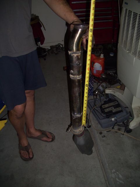 1995 Ford Probe - A person holds an exhaust pipe and catalytic converter next to a tape measure for size reference.